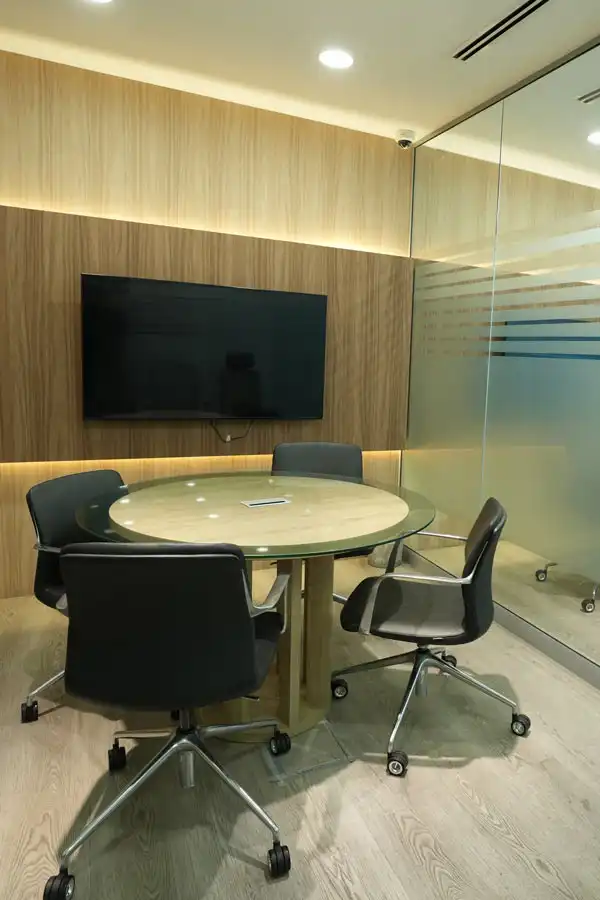 Conference room fit-out by Blueprint Experts – glass-walled meeting space with modern table, chairs, and large TV screen.