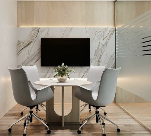 Small meeting room fit-out by Blueprint Experts – marble wall backdrop, round table, and modern chairs. Concept