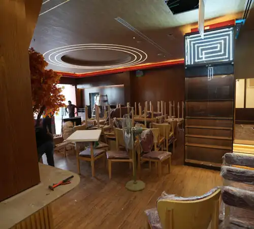 Contemporary restaurant interior with warm wooden flooring and elegant ceiling lights by Blueprint Experts
