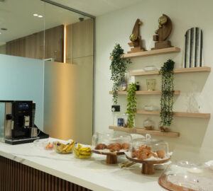 Pantry area fit-out by Blueprint Experts – countertop with snacks, coffee machine, decorative shelves, and green accents.