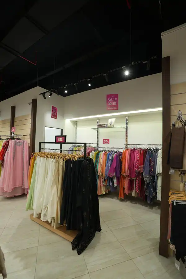 Wide-angle view of retail store showcasing garment racks and central seating by Blueprint Experts.