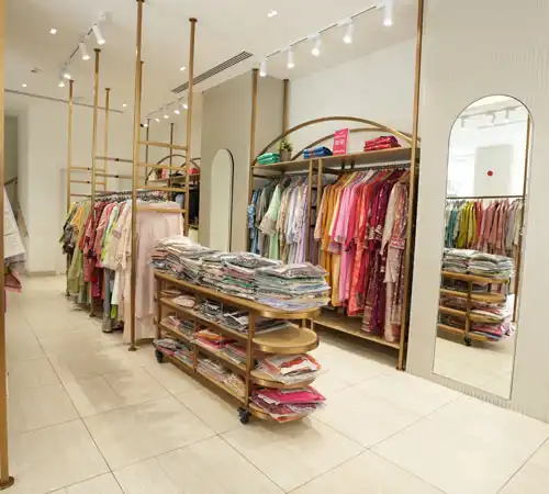 Retail clothing store featuring folded garments on wooden display shelves by Blueprint Experts.