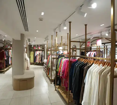 Wide-angle view of retail store showcasing garment racks and central seating by Blueprint Experts.