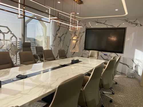 Luxury conference room fit-out by Blueprint Experts – long marble meeting table, comfortable chairs, and designer lighting.