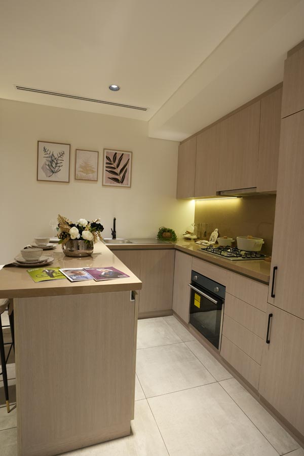 Modern residential kitchen interior designed with compact cabinetry, lighting, and decor accents.