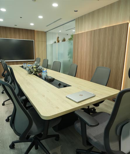Executive office conference room with long meeting table and wooden accents by Blueprint Experts