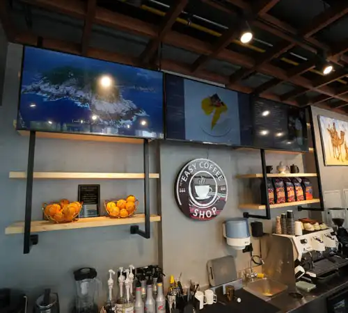 Coffee shop interior by Blueprint Experts – stylish café setup with display counter, espresso machines, and wall décor.
