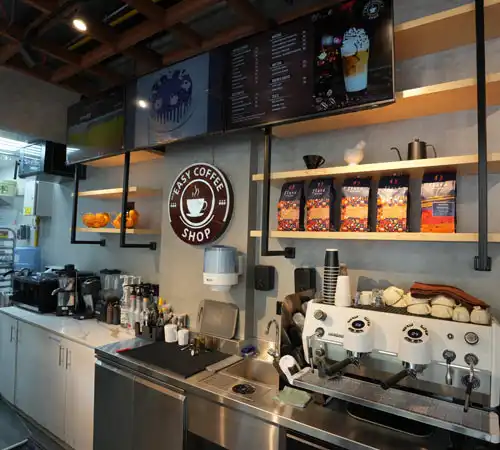 Coffee counter fit-out by Blueprint Experts – espresso machines, coffee branding, and organized product displays.