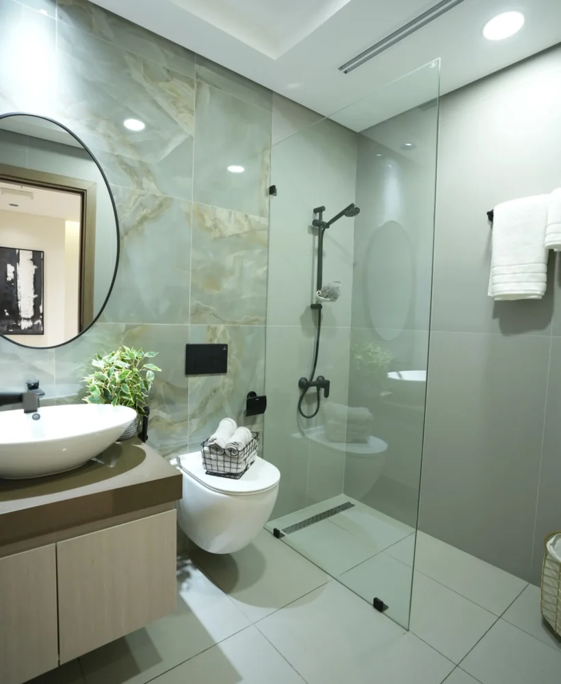 Luxury bathroom interior design with glass shower enclosure, rainfall shower, marble-effect wall tiles, and premium bathroom fit out by Blueprint Experts Dubai.