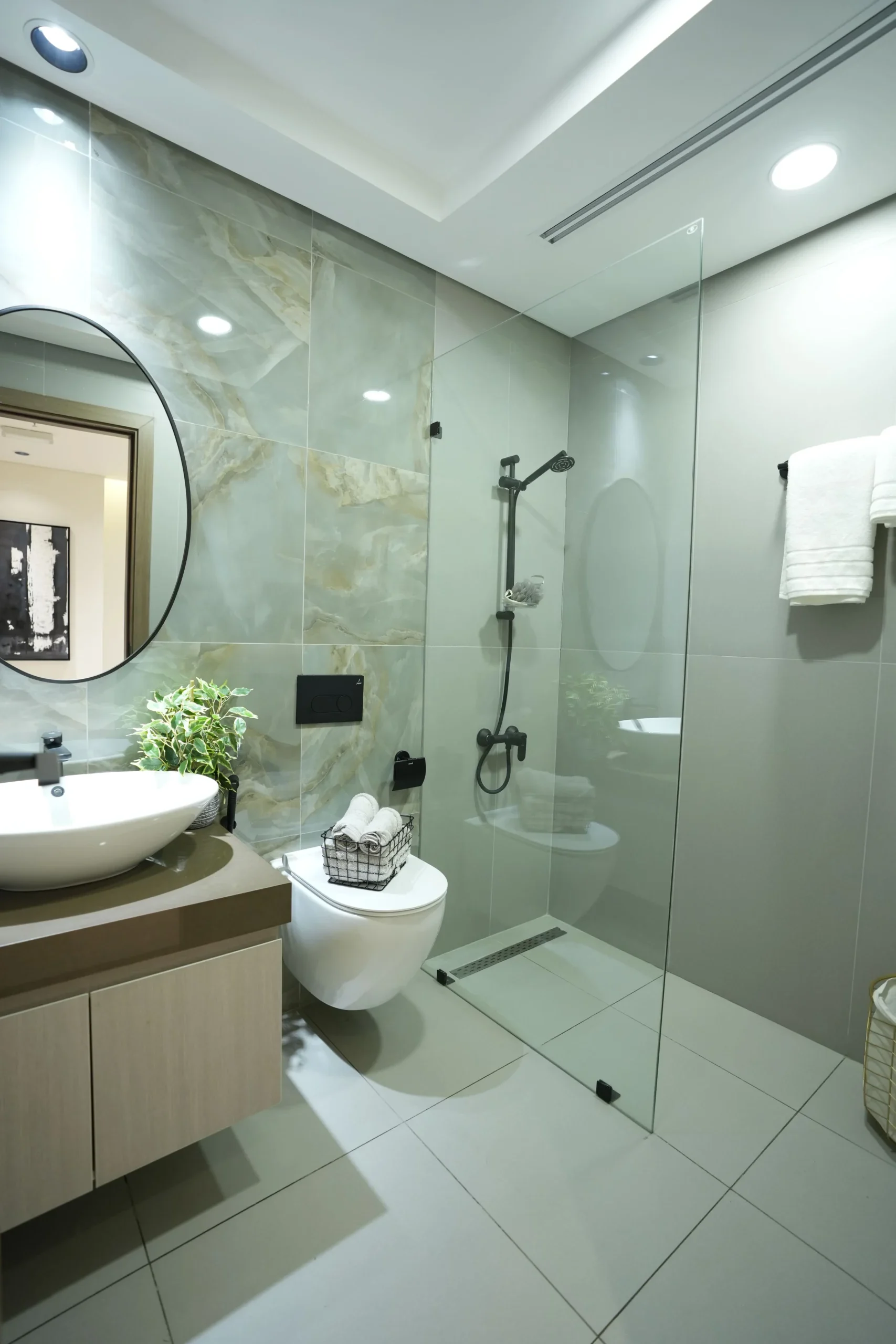 Luxury bathroom interior design with glass shower enclosure, rainfall shower, marble-effect wall tiles, and premium bathroom fit out by Blueprint Experts Dubai.