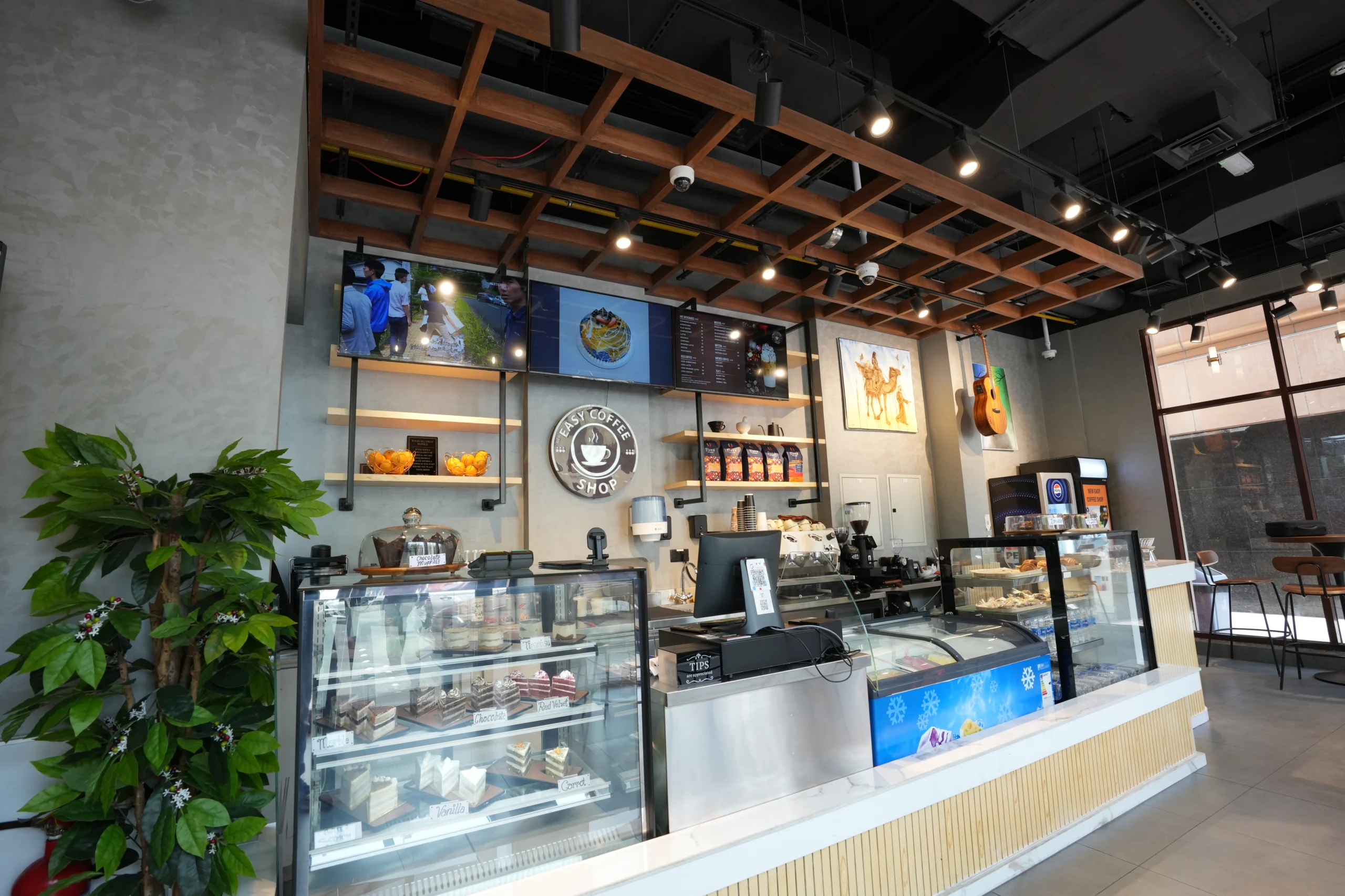 Coffee shop interior fit out with pastry display counters, wooden ceiling grid design and professional barista station setup