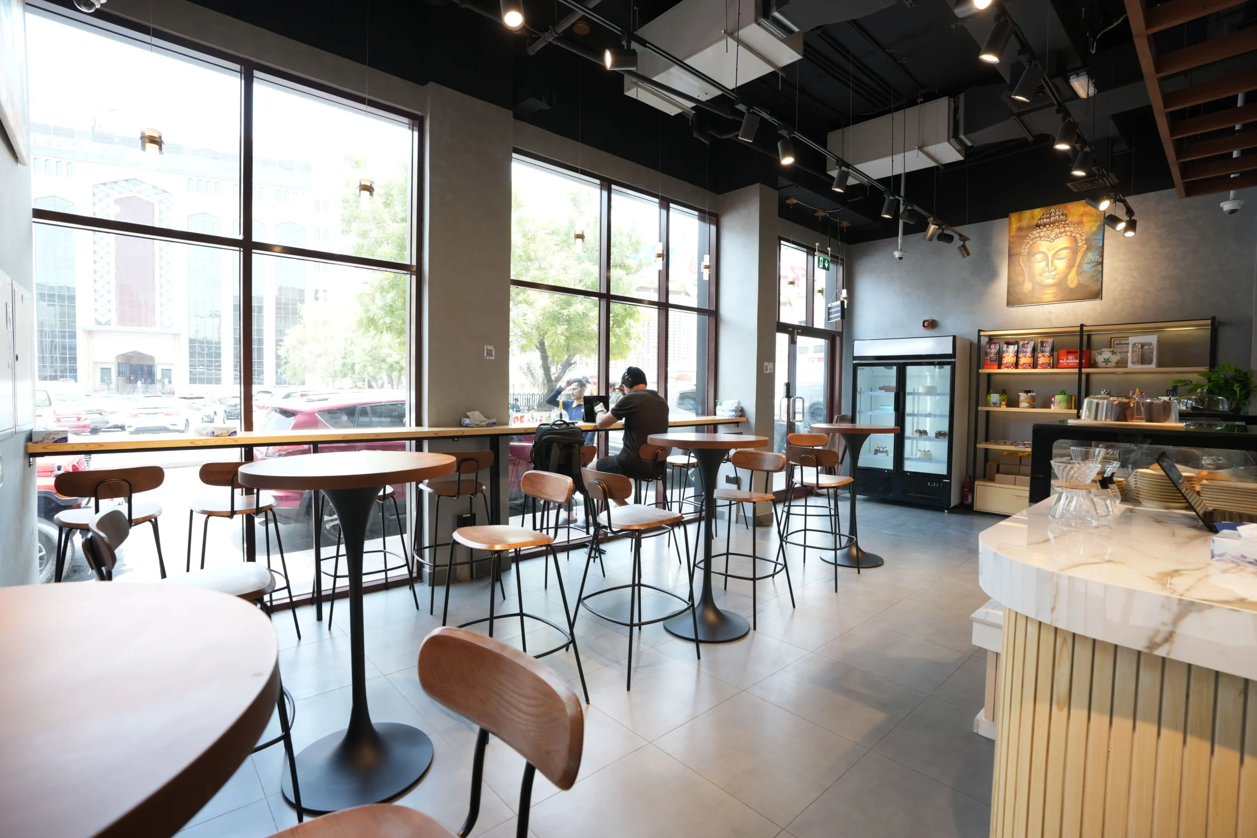 Café interior fit out with modern seating, natural lighting and comfortable dining space design by Blueprint Experts Dubai