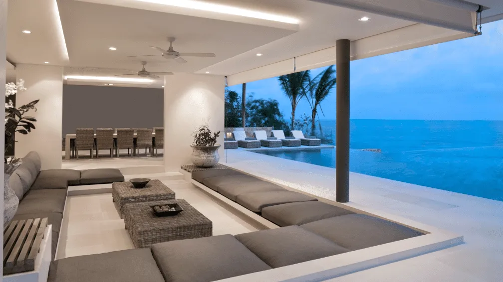 Luxury villa outdoor living interior fit-out by Blueprint Experts – elegant open-plan lounge with modern seating, poolside relaxation area, ocean views, and contemporary lighting design.