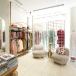 Retail interior fit out for boutique clothing store with custom shelving, display racks and luxury seating by Blueprint Experts